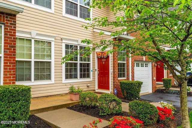 2420 Canterbury Ln, North Brunswick, NJ 08902 - property entrance featuring an attached garage and brick siding