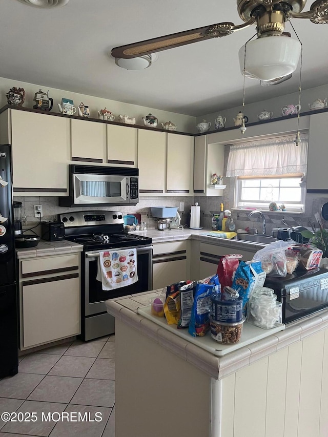 27 Maracaibo Pl, Toms River, NJ 08757 - kitchen featuring appliances with stainless steel finishes, tile counters, tasteful backsplash, light tile patterned floors, and white cabinetry