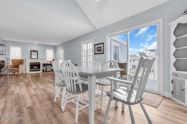 3 Drake Dr, Bayville, NJ 08721 - dining room featuring light wood finished floors, a warm lit fireplace, vaulted ceiling, and baseboards