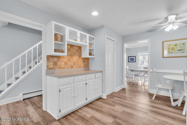 3 Drake Dr, Bayville, NJ 08721 - kitchen featuring a baseboard radiator, light wood-style flooring, glass insert cabinets, backsplash, and light countertops