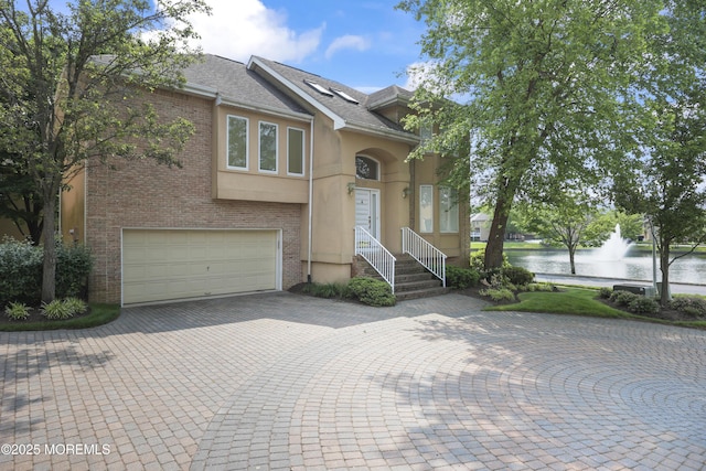 117 Sequoia Woods Ct, Holmdel, NJ 07733 - view of front of property featuring a water view, an attached garage, brick siding, driveway, and a shingled roof