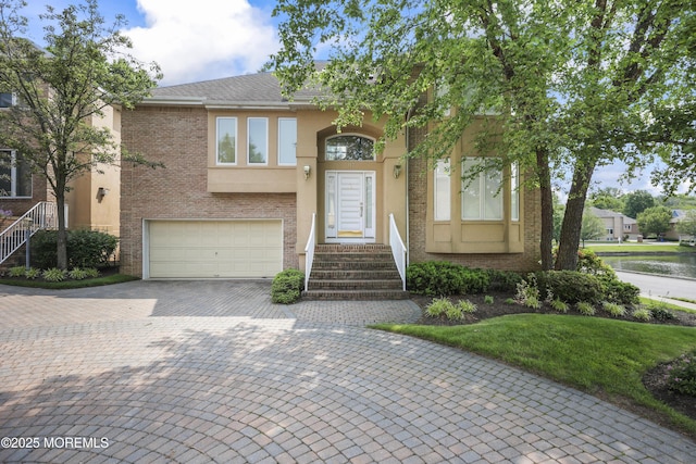 117 Sequoia Woods Ct, Holmdel, NJ 07733 - view of front of house with an attached garage, stucco siding, driveway, and brick siding