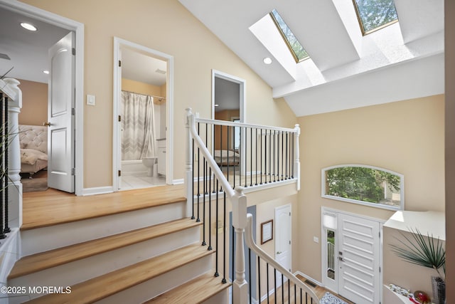 117 Sequoia Woods Ct, Holmdel, NJ 07733 - staircase featuring a skylight, high vaulted ceiling, wood finished floors, recessed lighting, and baseboards