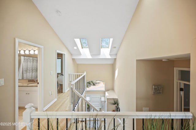 117 Sequoia Woods Ct, Holmdel, NJ 07733 - corridor featuring an upstairs landing, a skylight, high vaulted ceiling, baseboards, and wood finished floors