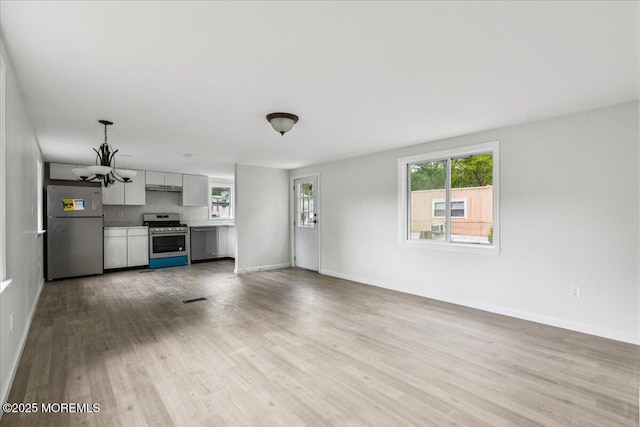 46 Roberts Rd, Toms River, NJ 08755 - unfurnished living room with wood finished floors, a chandelier, and baseboards