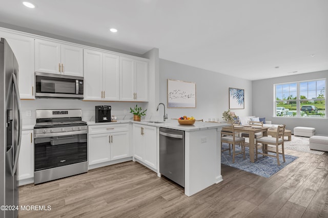 750 Lighthouse Dr Unit 1112, Barnegat, NJ 08005 - kitchen featuring appliances with stainless steel finishes, light wood-style flooring, a sink, open floor plan, and a peninsula