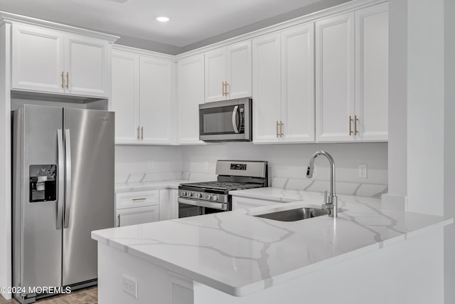 750 Lighthouse Dr Unit 1112, Barnegat, NJ 08005 - kitchen featuring stainless steel appliances, a sink, a peninsula, light stone counters, and white cabinets