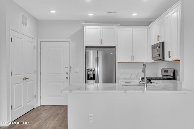 750 Lighthouse Dr Unit 1112, Barnegat, NJ 08005 - kitchen with stainless steel appliances, white cabinets, a peninsula, light wood-style floors, and recessed lighting