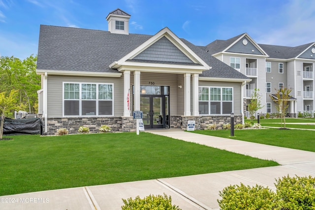 750 Lighthouse Dr Unit 1103, Barnegat, NJ 08005 - view of front facade featuring stone siding, french doors, a front lawn, and a shingled roof