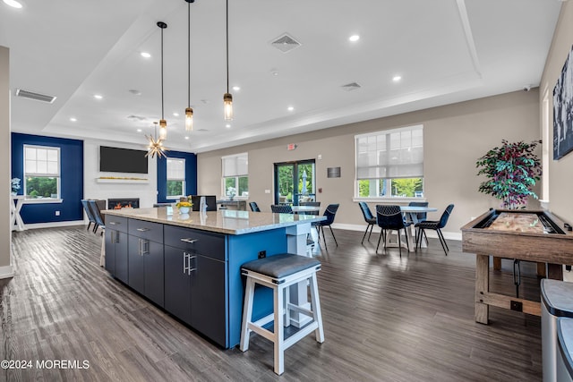 750 Lighthouse Dr Unit 3301, Barnegat, NJ 08005 - kitchen featuring a tray ceiling, a kitchen island, a lit fireplace, dark wood finished floors, and baseboards