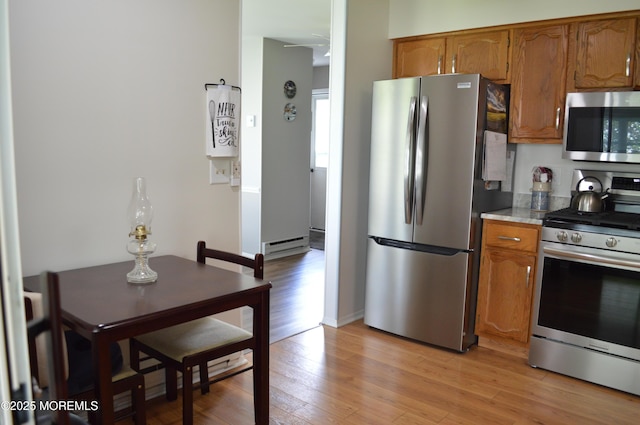 14 Ardsley Ave Unit 64, Whiting, NJ 08759 - kitchen with appliances with stainless steel finishes, brown cabinets, light wood-style floors, light countertops, and baseboard heating