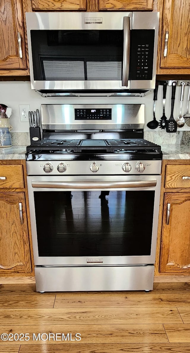 14 Ardsley Ave Unit 64, Whiting, NJ 08759 - kitchen with appliances with stainless steel finishes, light countertops, brown cabinetry, and light wood-type flooring