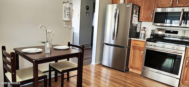 14 Ardsley Ave Unit 64, Whiting, NJ 08759 - kitchen featuring appliances with stainless steel finishes, brown cabinets, light wood-style floors, and light countertops