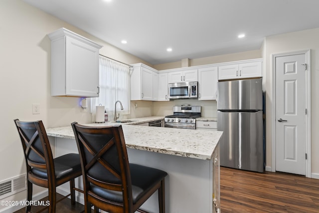 8 Carter Way, Brick, NJ 08723 - kitchen with appliances with stainless steel finishes, a peninsula, white cabinetry, dark wood-type flooring, and recessed lighting