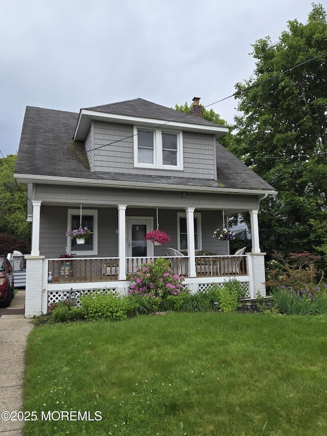 369 Indiana Ave, Long Branch, NJ 07740 - view of front of home featuring a porch, a chimney, a front lawn, and roof with shingles