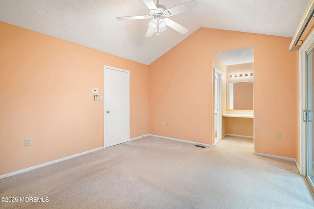 29 Copley Ct Unit 6, Freehold, NJ 07728 - unfurnished bedroom with light carpet, lofted ceiling, baseboards, ceiling fan, and a textured ceiling