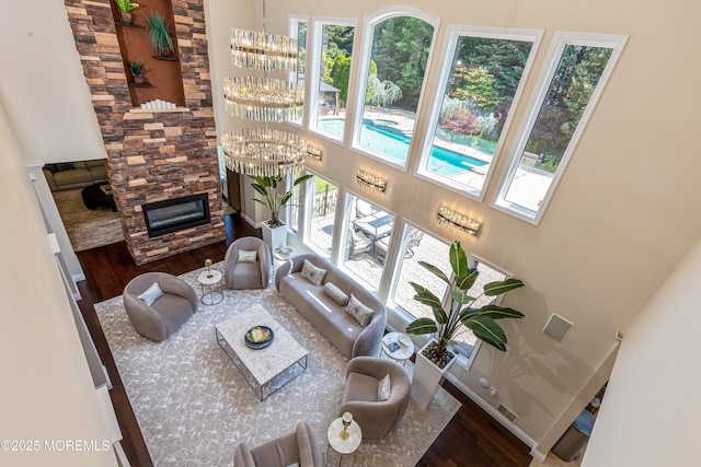 806 Turquoise Trl, Morganville, NJ 07751 - living room featuring wood finished floors, a fireplace, a chandelier, and a high ceiling