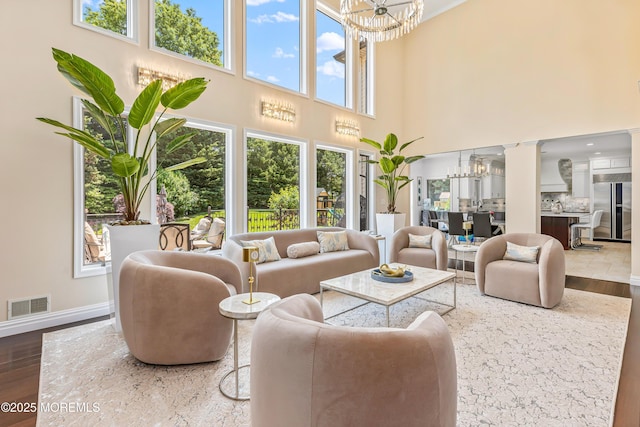 806 Turquoise Trl, Morganville, NJ 07751 - living area with a chandelier, a towering ceiling, and wood finished floors