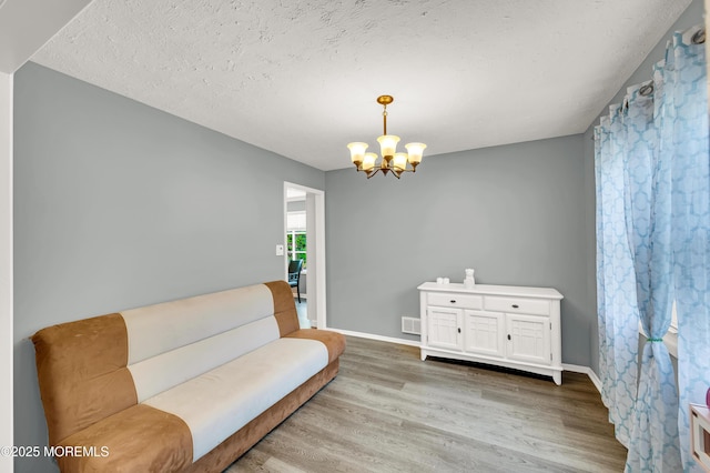 512 Highland Ter, Brick, NJ 08723 - sitting room featuring light wood-style flooring, a chandelier, baseboards, and a textured ceiling