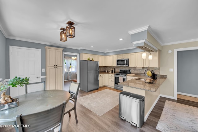 512 Highland Ter, Brick, NJ 08723 - kitchen featuring stainless steel appliances, cream cabinetry, a sink, a peninsula, and crown molding