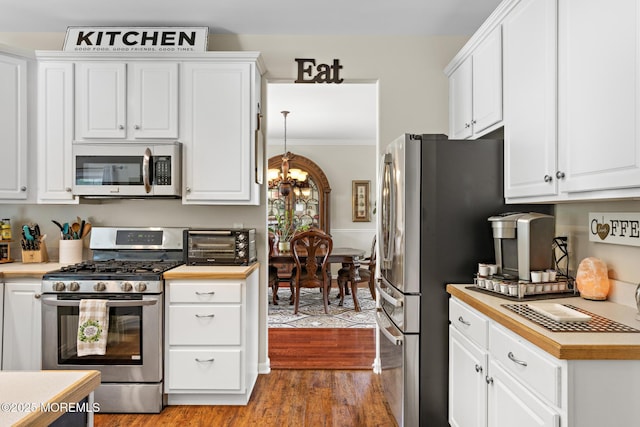 28 Hannah Lee Rd, Barnegat, NJ 08005 - kitchen with appliances with stainless steel finishes, a chandelier, white cabinetry, and ornamental molding