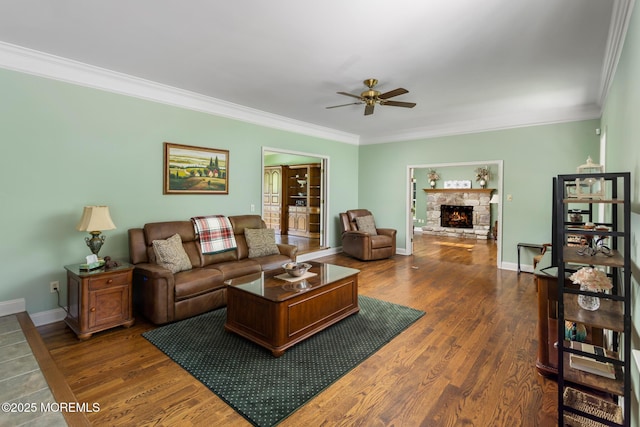 1 Yeger Dr, Upper Freehold, NJ 08501 - living room with a ceiling fan, ornamental molding, baseboards, a stone fireplace, and dark wood-style flooring