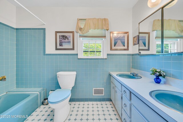 2146 Spruce Dr, Sea Girt, NJ 08750 - full bath featuring double vanity, toilet, wainscoting, and tile walls