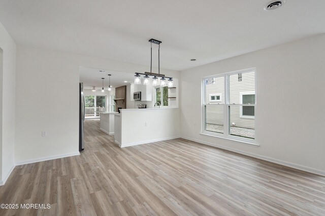 21 Turnbridge, Manchester, NJ 08759 - unfurnished living room featuring light wood finished floors, baseboards, and a sink