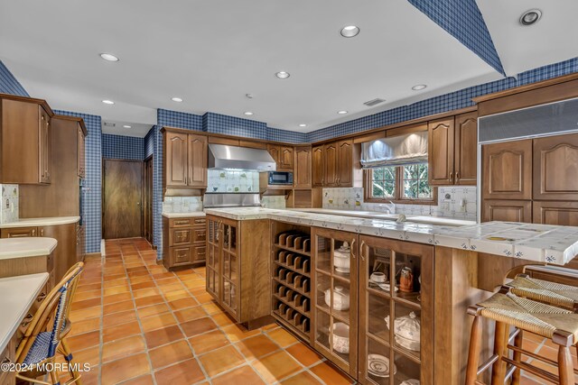 34 Bruns Rd, West Allenhurst, NJ 07711 - kitchen with range hood, black microwave, light countertops, wallpapered walls, and backsplash