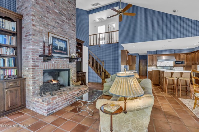 34 Bruns Rd, West Allenhurst, NJ 07711 - living room with a high ceiling, ceiling fan, tile patterned flooring, a fireplace, and stairway