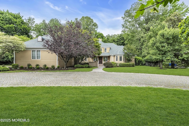 34 Bruns Rd, West Allenhurst, NJ 07711 - view of front facade with a front yard, stucco siding, and a chimney