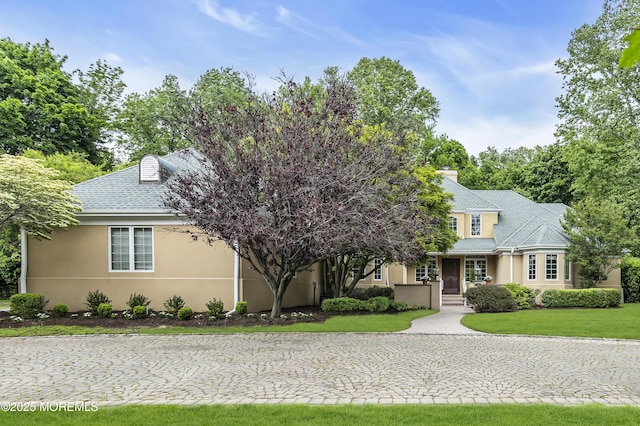 34 Bruns Rd, West Allenhurst, NJ 07711 - view of front facade featuring stucco siding, a front yard, and a shingled roof