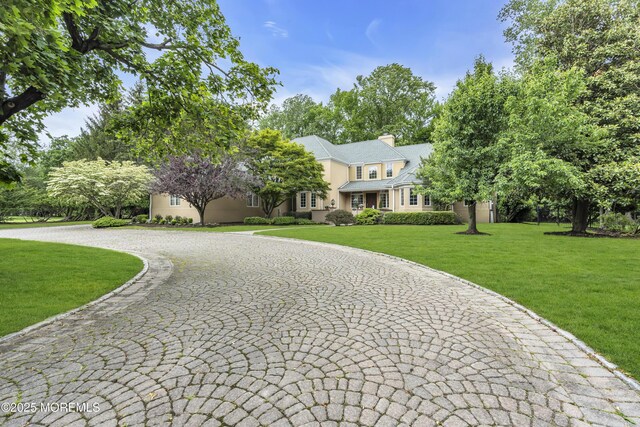 34 Bruns Rd, West Allenhurst, NJ 07711 - view of front of home with a front lawn, a chimney, and stucco siding