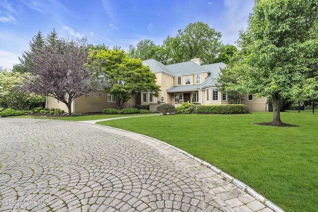 34 Bruns Rd, West Allenhurst, NJ 07711 - view of front facade with stucco siding, a front lawn, and a chimney