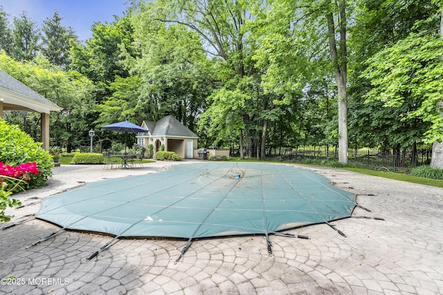 34 Bruns Rd, West Allenhurst, NJ 07711 - view of pool featuring a patio area, view of wooded area, and an outbuilding