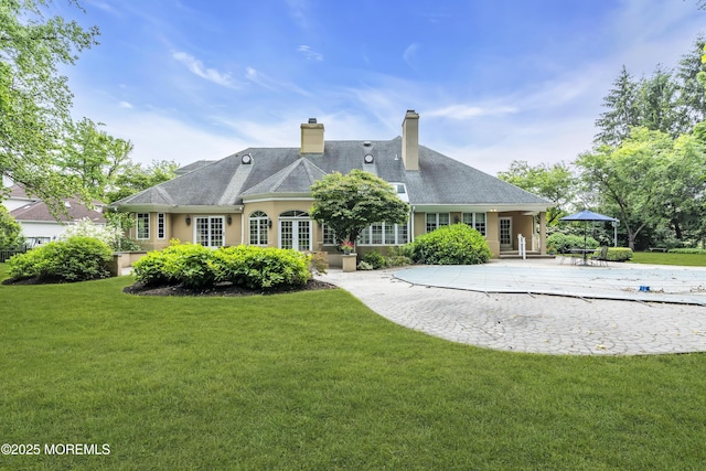 34 Bruns Rd, West Allenhurst, NJ 07711 - rear view of property featuring a patio, a lawn, and a chimney