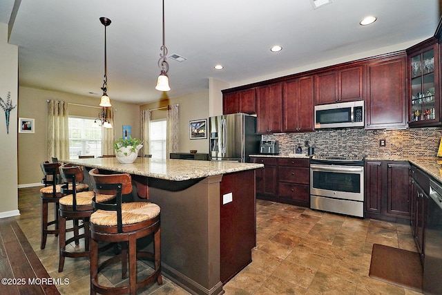 46 Rockland St, Barnegat, NJ 08005 - kitchen featuring stainless steel appliances, tasteful backsplash, a kitchen island, reddish brown cabinets, and hanging light fixtures