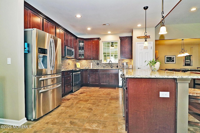 46 Rockland St, Barnegat, NJ 08005 - kitchen featuring stainless steel appliances, decorative backsplash, light stone counters, pendant lighting, and a center island
