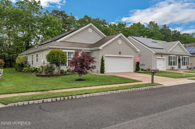 85 Briarwood Dr, Little Egg Harbor, NJ 08087 - view of front facade with an attached garage, a front yard, concrete driveway, roof with shingles, and roof mounted solar panels