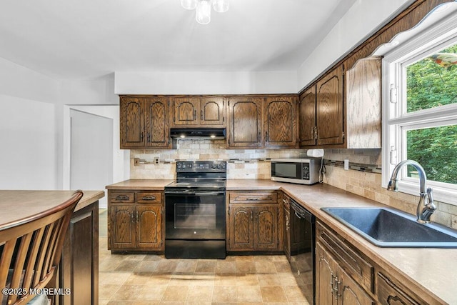 25 Overhill Rd, Ocean Twp, NJ 07712 - kitchen featuring black appliances, under cabinet range hood, a sink, backsplash, and light countertops