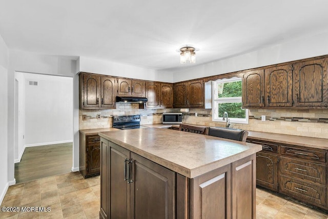 25 Overhill Rd, Ocean Twp, NJ 07712 - kitchen featuring stainless steel microwave, under cabinet range hood, black range oven, a sink, and a center island