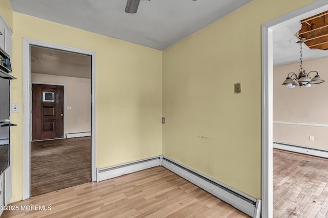 812 Donna Dr, Point Pleasant, NJ 08742 - unfurnished room with light wood-type flooring, a baseboard heating unit, a baseboard radiator, and a chandelier
