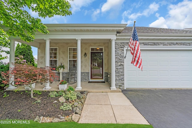 5 Minot Light Ct, Barnegat, NJ 08005 - view of exterior entry featuring covered porch, stone siding, driveway, stucco siding, and an attached garage