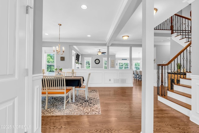 342 Old Squan Rd, Brick, NJ 08724 - dining space with crown molding, stairway, wood finished floors, a chandelier, and a decorative wall