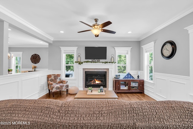 342 Old Squan Rd, Brick, NJ 08724 - living area featuring wood finished floors, plenty of natural light, a tile fireplace, a wainscoted wall, and a ceiling fan