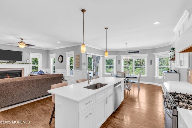 342 Old Squan Rd, Brick, NJ 08724 - kitchen with a sink, stainless steel appliances, light countertops, ceiling fan, and a glass covered fireplace