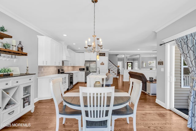 342 Old Squan Rd, Brick, NJ 08724 - dining space with stairs, a chandelier, healthy amount of natural light, crown molding, and light wood-type flooring