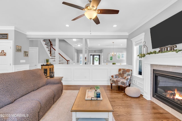 342 Old Squan Rd, Brick, NJ 08724 - living room featuring wood finished floors, stairway, a tiled fireplace, a decorative wall, and crown molding
