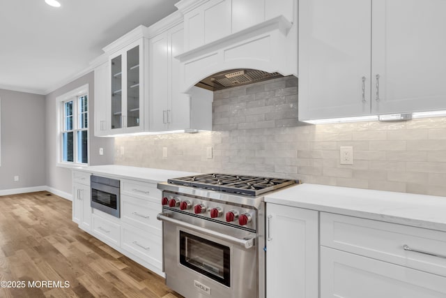 516 13th Ave, Belmar, NJ 07719 - kitchen featuring stainless steel appliances, premium range hood, white cabinets, baseboards, and glass insert cabinets