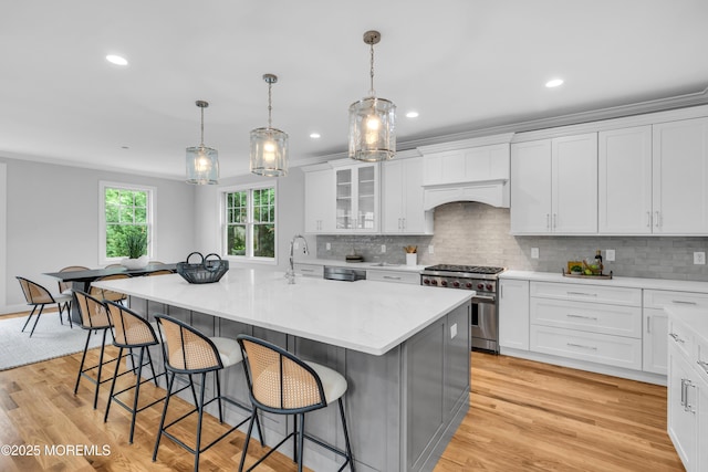 516 13th Ave, Belmar, NJ 07719 - kitchen featuring high end stainless steel range, a breakfast bar area, white cabinets, tasteful backsplash, and recessed lighting
